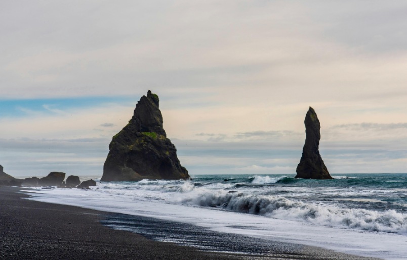 Bãi biển Reynisfjara nổi bật với cát đen và cột đá bazan Bãi Biển Reynisfjara Nổi Bật Với Cát Đen Và Cột Đá Bazan